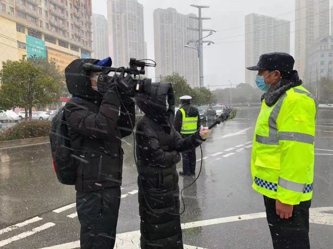 孝感市融媒體中心楊亞玲（風(fēng)雪中，采訪疫情期間重返一線的退休警察）_副本.jpg.jpg