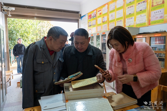 劉細(xì)谷向采訪團(tuán)成員展示他用雙腳書(shū)寫(xiě)的原稿.jpg